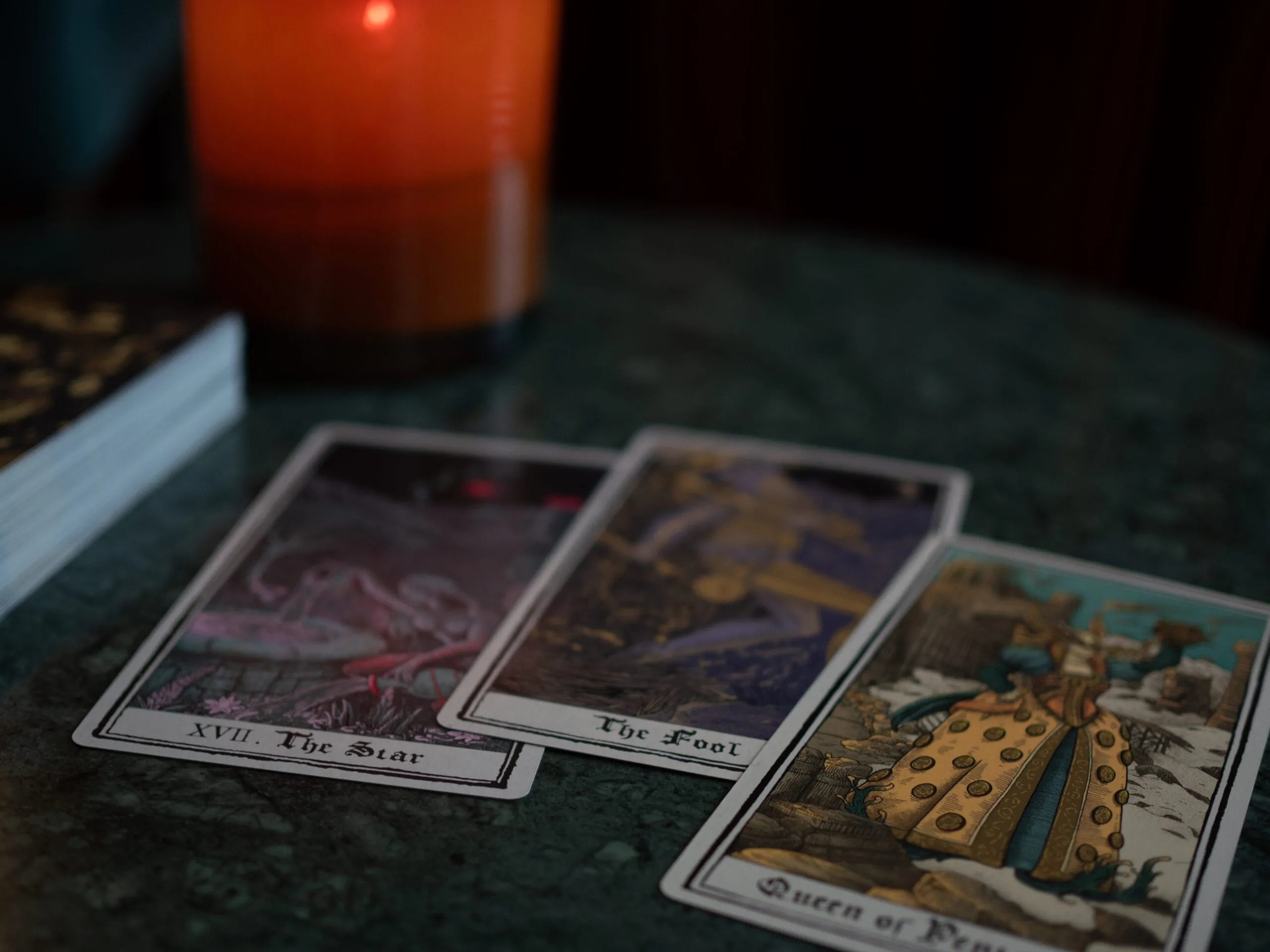 Cards from a reading laid out beside a burning candle