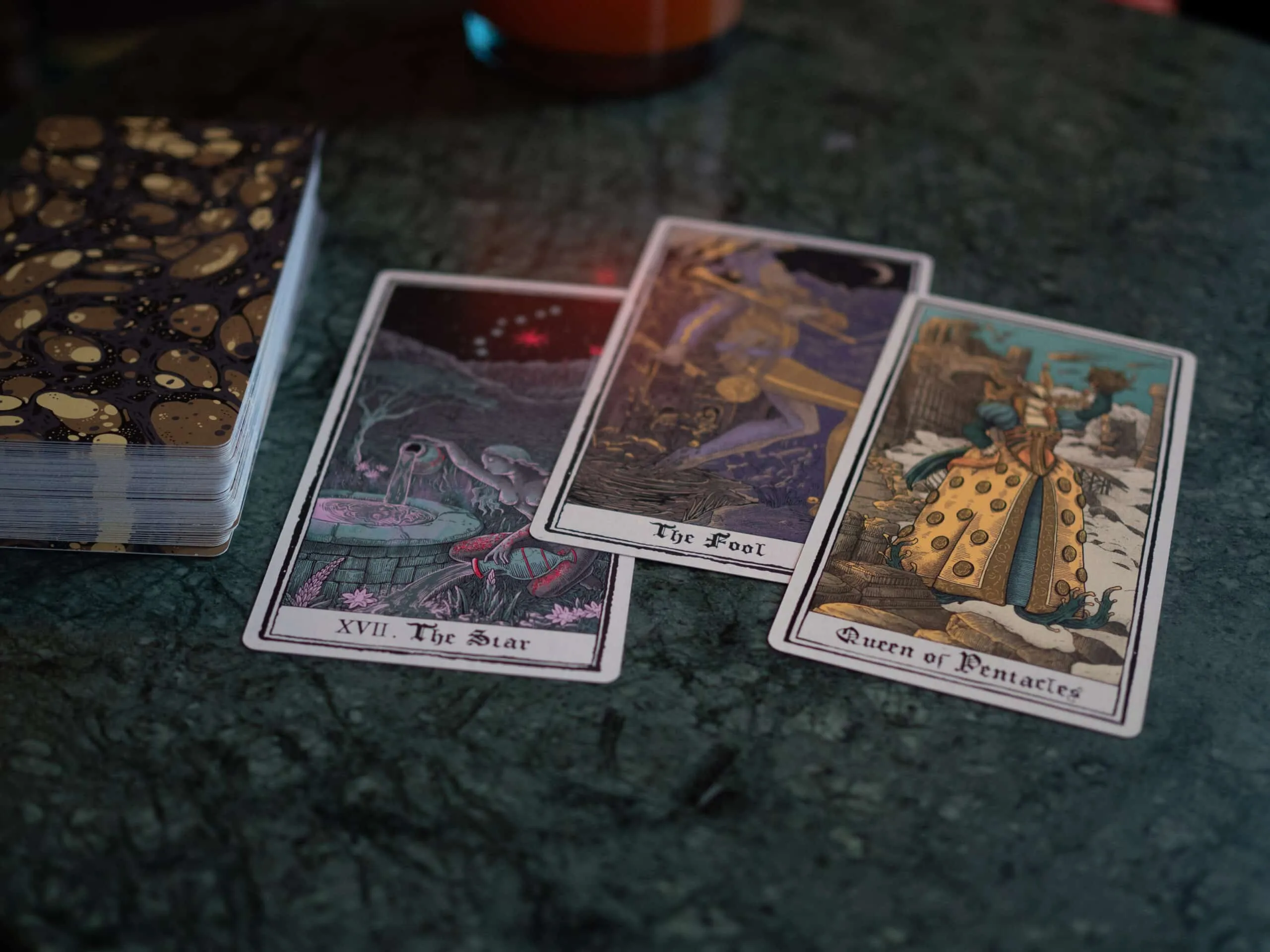 Tarot cards laid out on a dark stone surface in candlelight